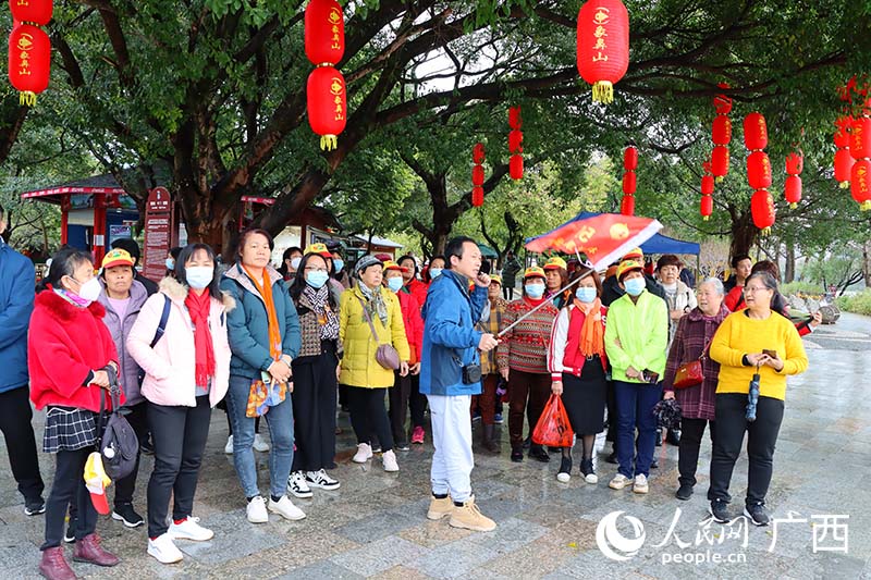 游客認(rèn)真聽導(dǎo)游講述象鼻山的故事。人民網(wǎng) 付華周攝