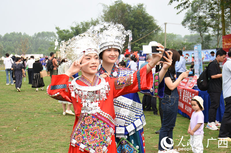 游客穿著少數(shù)民族特色服飾在景點(diǎn)打開拍照。人民網(wǎng) 王功孝攝