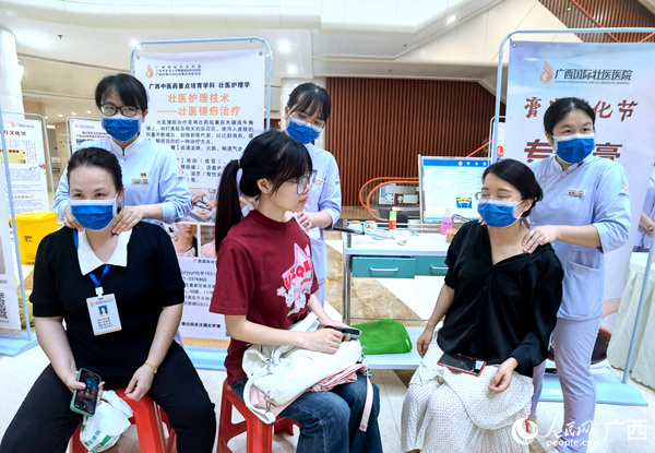 市民體驗(yàn)壯醫(yī)錘痧治療。人民網(wǎng)記者 陳燕攝