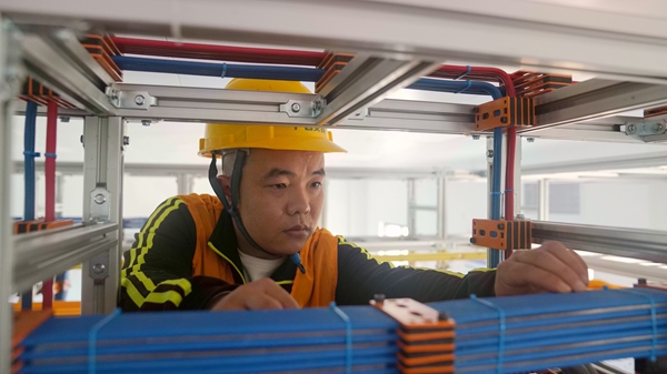 施工人員檢查機房上走線電纜布放。安智翔攝