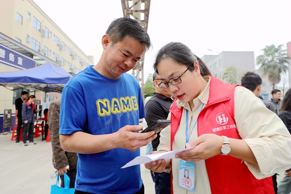 覃塘區(qū)零工市場工作人員向求職者推薦線上零公招聘群（李柳慧攝）.jpg