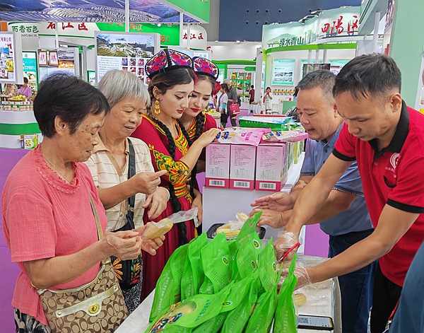 圖為參展企業(yè)在縣博會現(xiàn)場推薦忻城的農(nóng)特產(chǎn)品