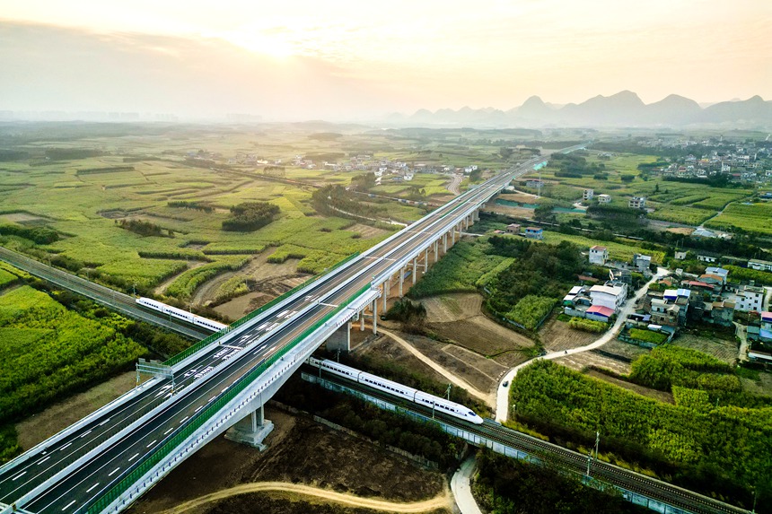列車從廣西單體噸位最大轉體橋——武忻高速維都上跨鐵路分離式立交特大橋飛馳而過。贠文豪攝