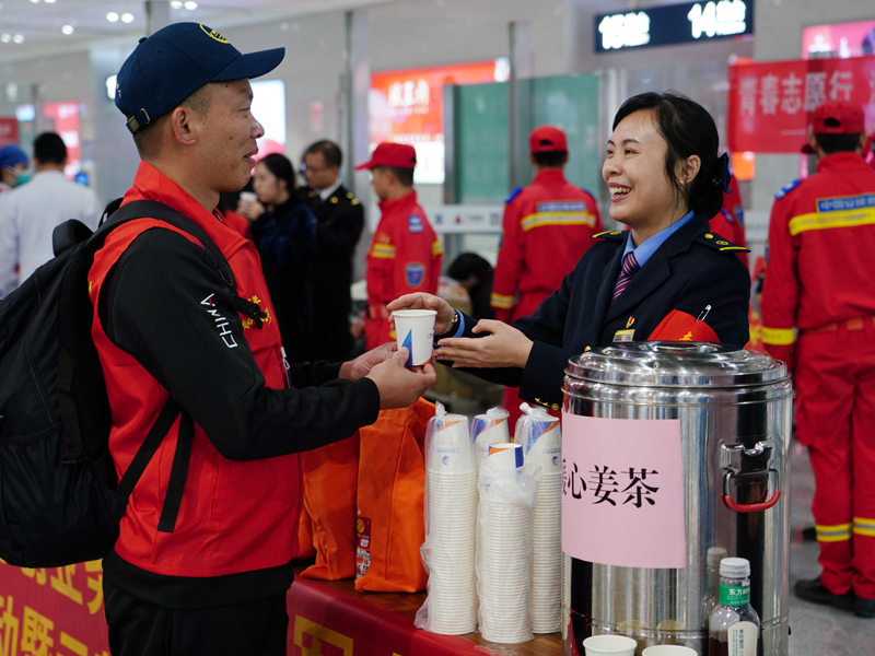 南寧東站工作人員為返鄉(xiāng)的退役軍人送上姜糖水。梁競輝攝