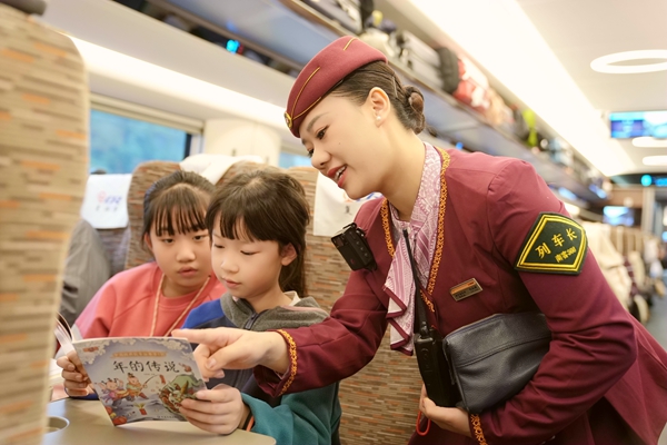 列車長楊亞楠向乘車的孩子提供繪本讀物。曹爍攝