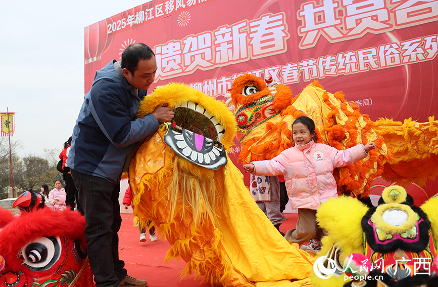 大人引導小孩體驗舞彩獅。人民網(wǎng) 付華周攝