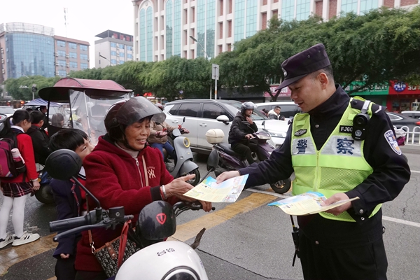 交警發(fā)放交通安全宣傳資料。陳君雨攝