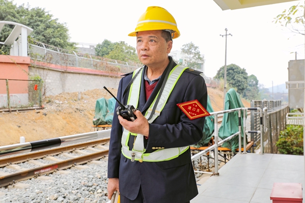 道口工朱貴華與機(jī)車司機(jī)進(jìn)行道機(jī)聯(lián)控。宋彤波攝