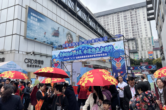 現(xiàn)場發(fā)放“愛南寧 愛民生”愛心傘 。尹曄華攝