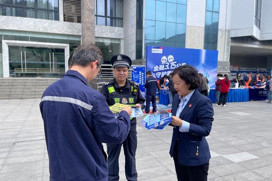 浦發(fā)銀行工作人員和派出所民警共同向工人發(fā)放電動(dòng)車安全提醒反光貼。馬淑琴攝