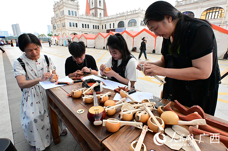市民們?cè)诜沁z展示體驗(yàn)坊體驗(yàn)制作天琴。人民網(wǎng) 雷琦竣攝