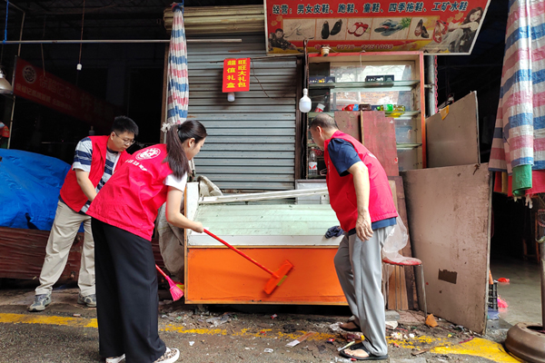 黨員同志幫助受災(zāi)商戶清理店面。李群攝